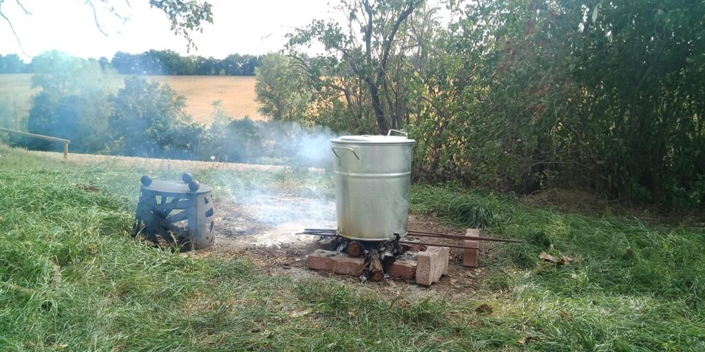 Image of hugeboiling pot, on wood fire outdoors.